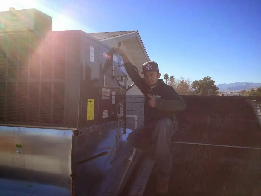 HVAC technician performing Boiler Repair on a rooftop unit in Oak Grove